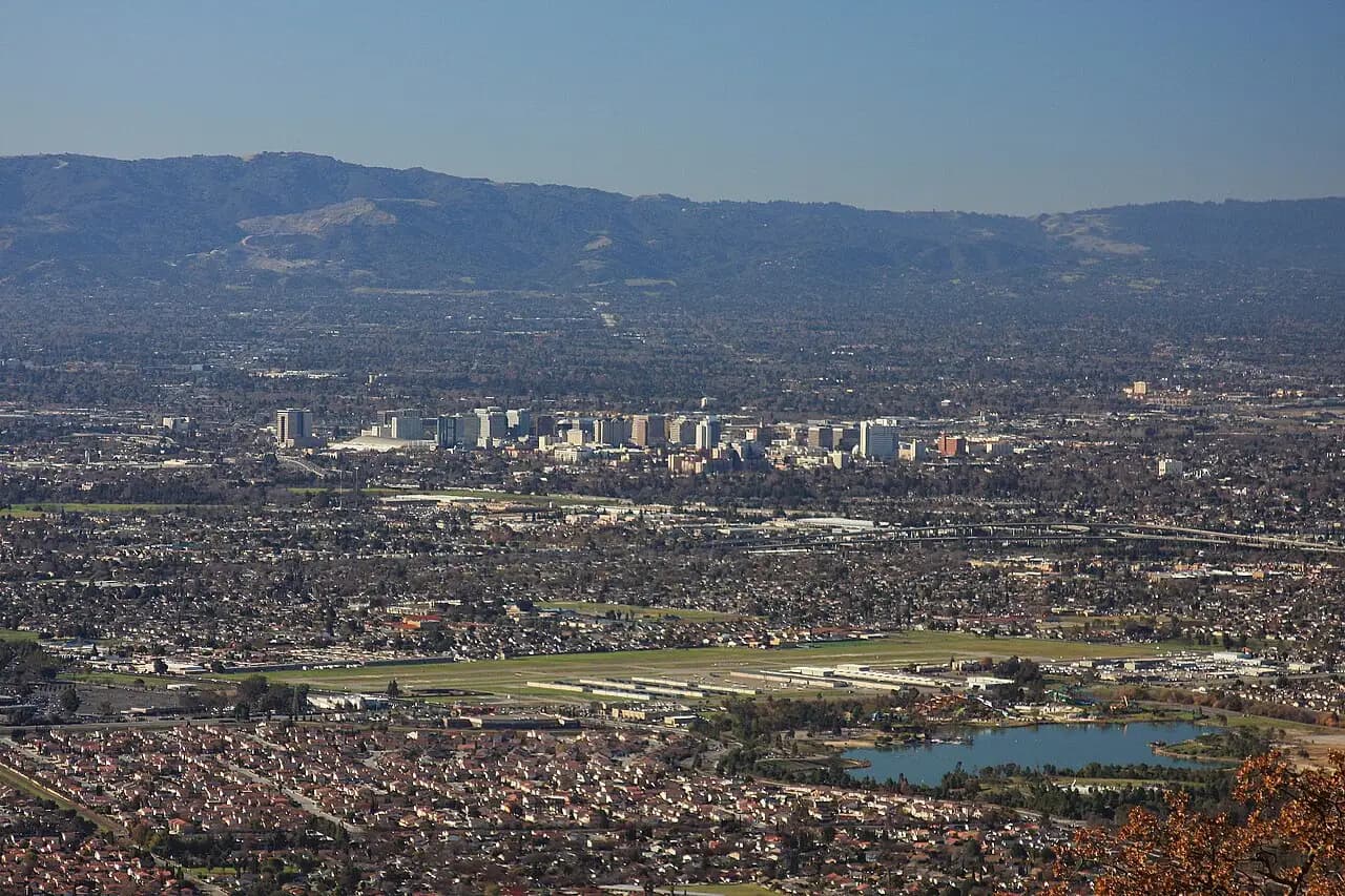 Daylight view across San Jose neighborhoods toward the downtown skyline and hills